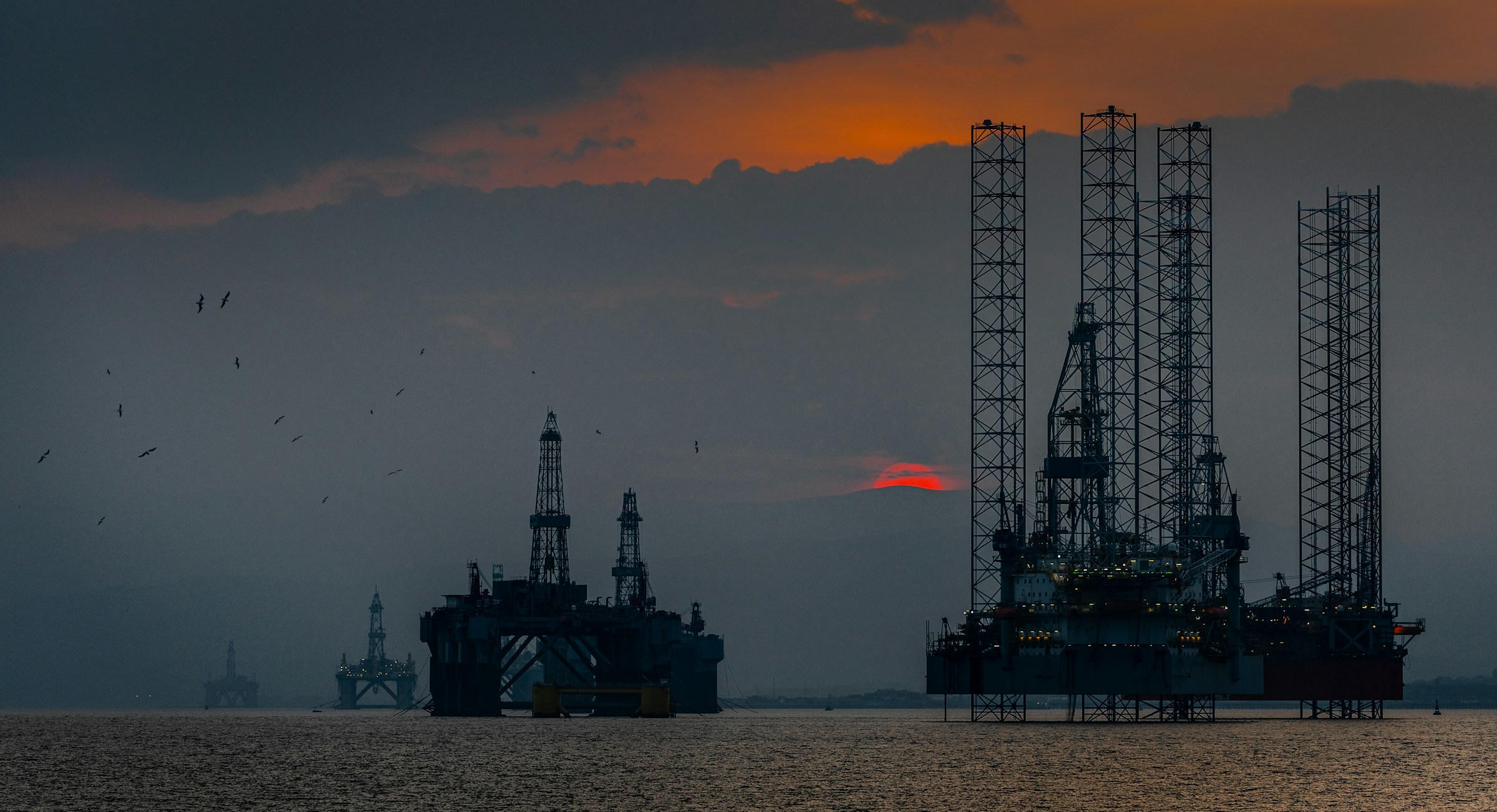 Offshore rigs at sunset